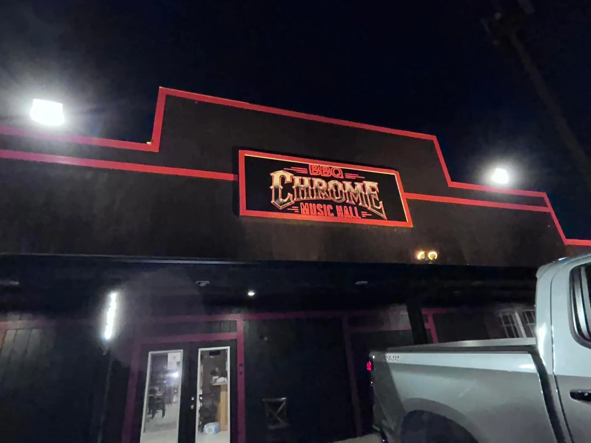 Chrome's illuminated BBQ Chrome Music Hall sign above the entrance at night